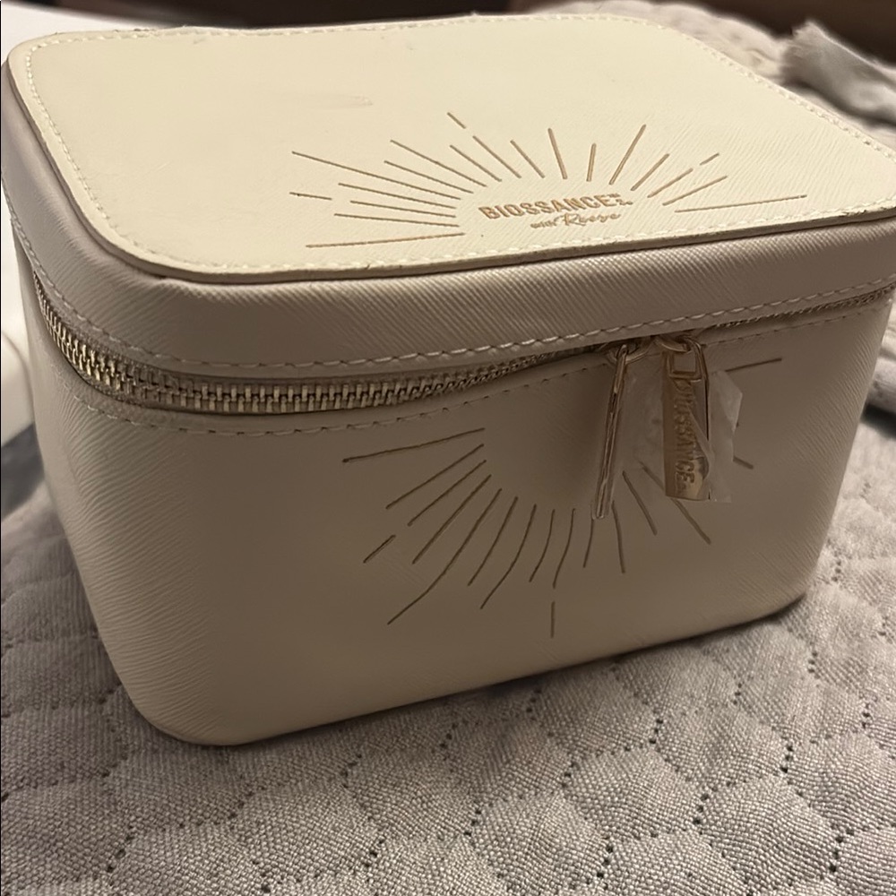 Biossance Cream Cosmetic Case with Sunburst Design